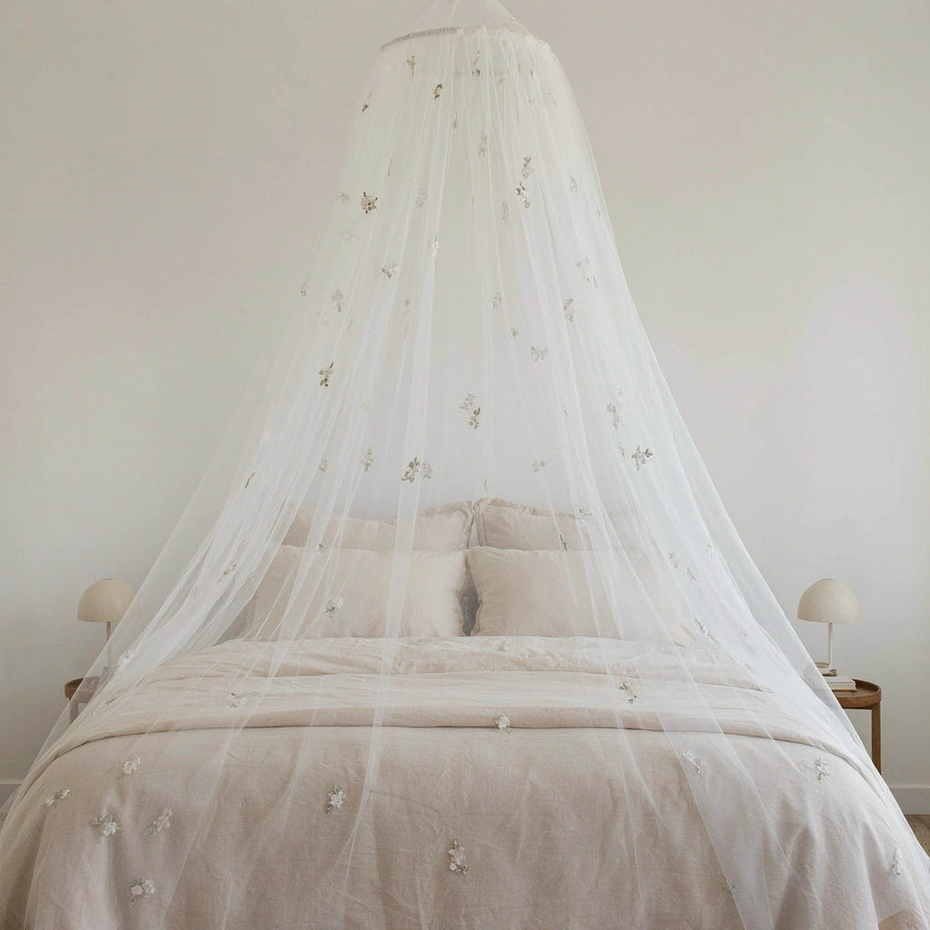 Dôme de tulle blanc brodé de fleurs au-dessus d'un lit double romantique