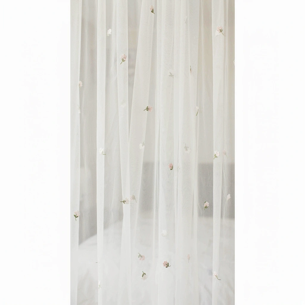 Panneaux de tulle brodé de fleurs sur un lit à baldaquin
